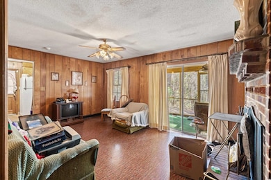 Living area featuring a ceiling fan, brick floor, 