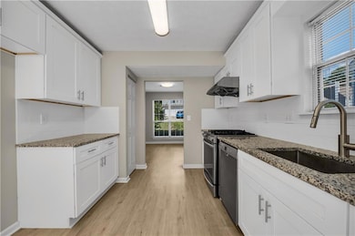 Kitchen with a sink, light wood finished floors, d