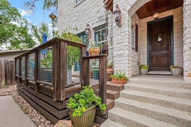 Doorway to property featuring stone siding and fe