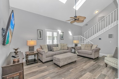 Living room with a skylight, visible vents, stairw