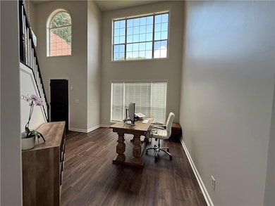 Home office featuring dark wood finished floors and a high ceiling