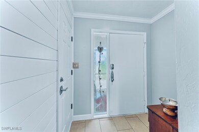 Foyer featuring light tile patterned floors and or