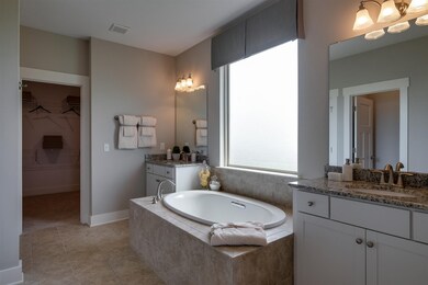 Not actual home, but home will have a separate soaker tub and walk in shower with a bench, ceramic surround and mosaic ceramic tile floor in the shower. Lots of natural light with the large window, which is frosted to maintain your privacy!