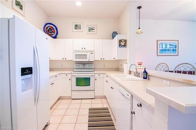 Kitchen with white cabinetry, kitchen peninsula, p