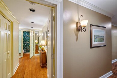 Hall featuring ornamental molding and light hardwo