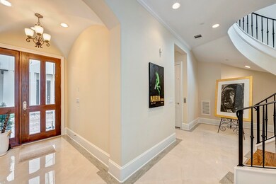 Formal entry with glass door and marble floors.