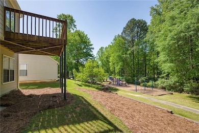 View of yard with a wooden deck and a playground