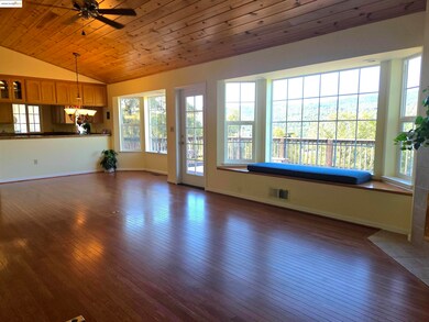 Now empty. It looks out to the deck of man made material. The vaulted wood ceiling and real wood floors are gorgeous! Behind the fireplace is the primary bedroom suite with sliding glass doors for exit or entry from same deck.