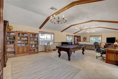 Great room featuring wallpapered walls, lofted cei