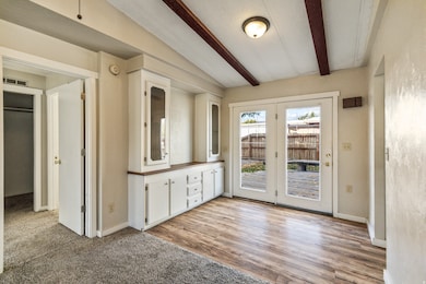 Doorway featuring beamed ceiling and carpet