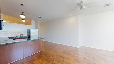 Kitchen featuring hanging light fixtures, tasteful backsplash, appliances with stainless steel finishes, dark wood finished floors, and a peninsula