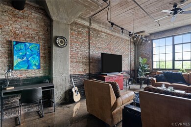 Living room with brick wall, concrete floors, and