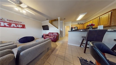 Living area featuring crown molding, light tile pa