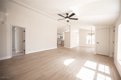 Unfurnished living room with lofted ceiling, baseb