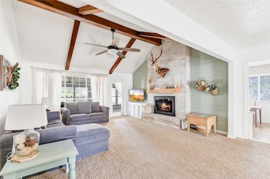 Vaulted ceilings, wood beams, shiplap accents, limewashed brick with updated mantle, and refreshed glass front gas fireplace.