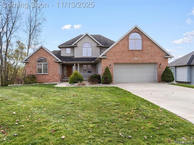 Traditional-style house with covered porch, brick siding, concrete driveway, and a front yard