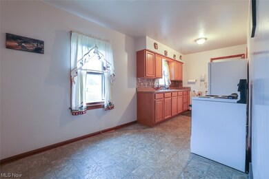 Kitchen featuring sink, white fridge, light tile flooring, and backsplash