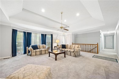 Living room with a tray ceiling, crown molding, an
