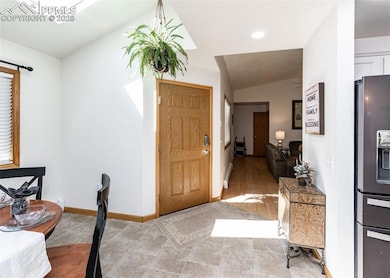 Foyer entrance featuring vaulted ceiling with skyl