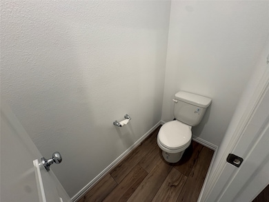 Bathroom with dark wood-style floors and baseboards