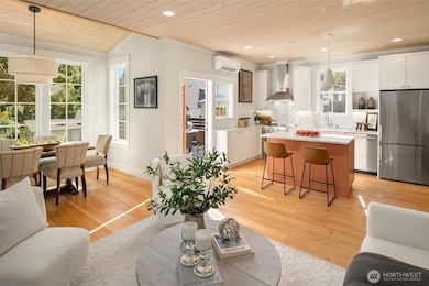 An expansive open layout provides comfortable living spaces illuminated by the stained wood paneled ceilings.