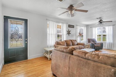 Living room with a textured ceiling, light wood-ty