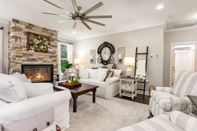 Living room with a fireplace, ceiling fan, and cro