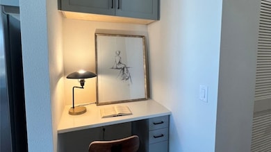 Cozy home office nook with a built-in desk and upper cabinet. It creates a functional and stylish workspace.