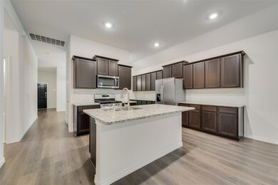 Kitchen featuring light hardwood / wood-style flooring, stainless steel appliances, sink, and light stone countertops