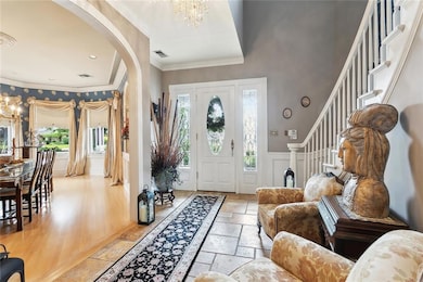 Foyer: Italian marble flooring, Gracefully curved stairway with coat closet under stairs Crystal chandelier, Stained glass window