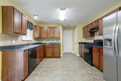 Kitchen has new tile back splash and lots of cabinets.
