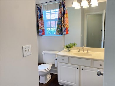 Half bathroom featuring vanity and wood finished floors