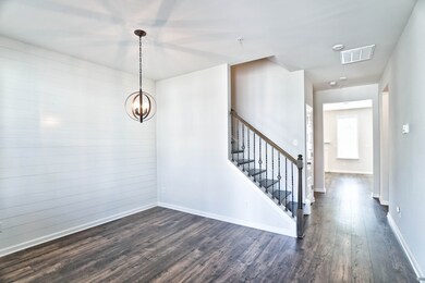 Step right into the dining room with a shiplap feature wall & views of the wrought iron banister.