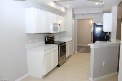 Kitchen with white cabinetry, sink, appliances wit
