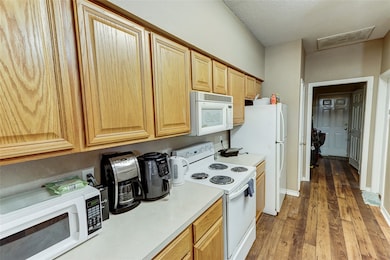 Kitchen featuring white appliances, wood finished