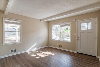 Entryway featuring dark hardwood / wood-style flooring, beamed ceiling, and a textured ceiling
