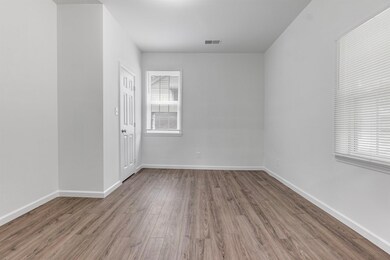 Empty room with baseboards, visible vents, and wood finished floors
