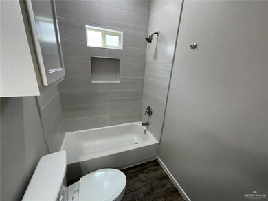 Bathroom featuring  shower combination and wood finished floors