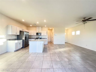 Kitchen with white cabinetry, stainless steel appliances, an island with sink, open floor plan, and recessed lighting