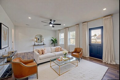 Living room featuring ceiling fan and dark hardwoo