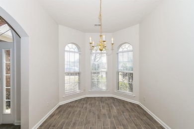 Unfurnished dining area featuring a chandelier, ba