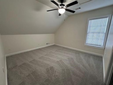 Bonus room with lofted ceiling, a ceiling fan, and carpet floors