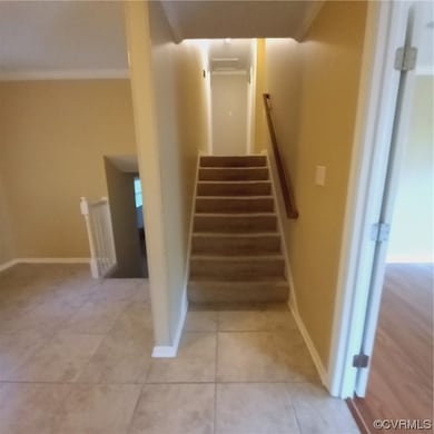 Stairs featuring ornamental molding and light tile floors