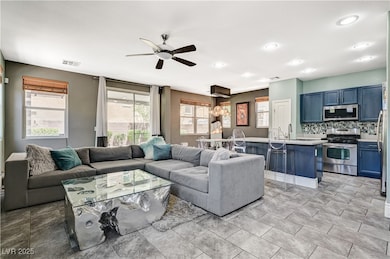 Living area featuring a ceiling fan and recessed l