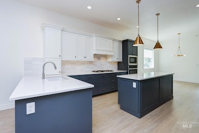 Kitchen featuring tasteful backsplash, light wood-style floors, white cabinetry, light countertops, and recessed lighting