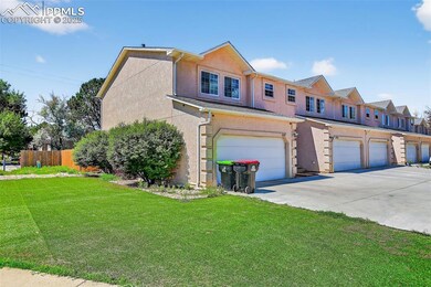 View of front of condominiums - with driveway, stucco siding, and a garages