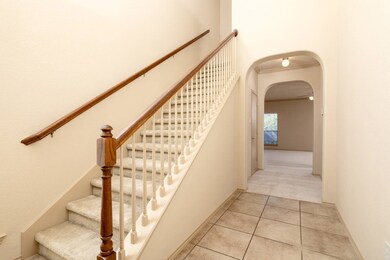 Stairway with arched walkways, tile patterned flooring, carpet flooring, and ornamental molding