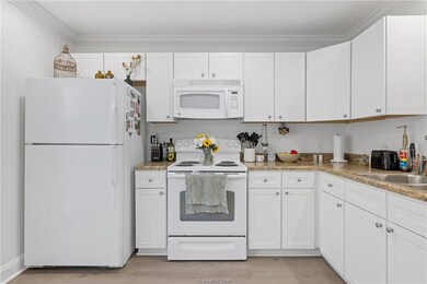 Kitchen with white appliances, light wood-style fl