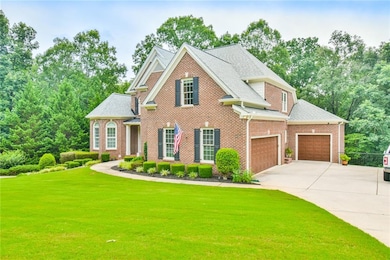 View of front facade featuring a front yard, driveway, brick siding, and a shingled roof