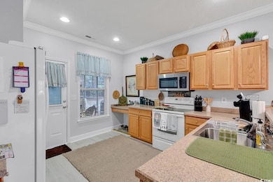 Kitchen featuring crown molding, light brown cabin